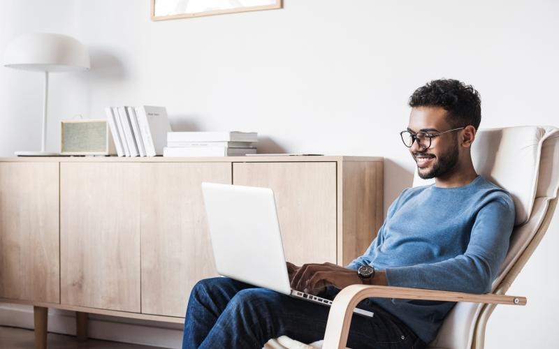 a man sitting in a chair with a laptop