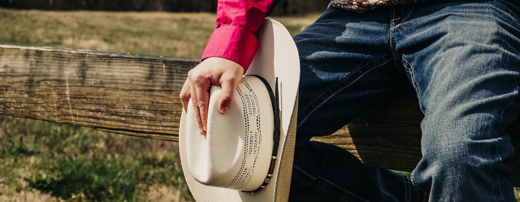 a cowboy sitting on a fence