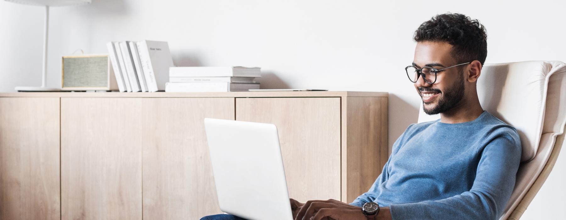 a man sitting in a chair with a laptop